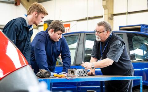 Motor Vehicle students examining a car part