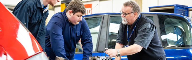 Motor Vehicle students examining a car part